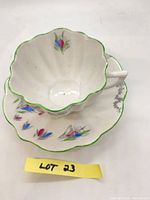 Teacup nested in saucer showing overall design and lot label