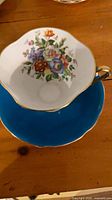 Top view showing floral interior of teacup and blue saucer
