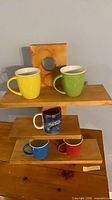 Front view of wood shelf with five mugs displayed