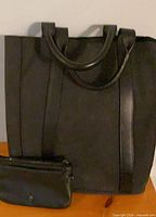 Front view of black faux leather tote with pouch