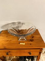Front view of clear faceted crystal compote on wood surface