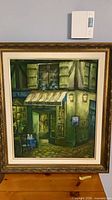 Full view of framed acrylic painting showing café scene in ornate gold frame