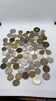 Wide view showing full assortment of mixed coins spread out for count and composition visibility