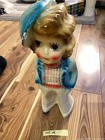 front view of ceramic chalkware child figurine showing colors and overall form
