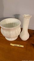 Planter and vase side by side on wooden surface