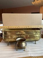 Long brass footed planter and small three-legged pot with ruler showing length