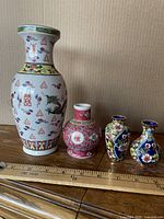 All four vases lined up against ruler for scale