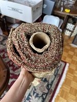 Roll of burgundy and gold jacquard upholstery fabric on cardboard core