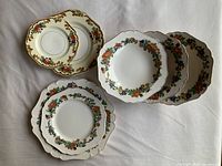 Stacked Minerva pattern plates and bowls showing floral border and gold trim