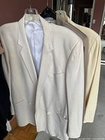 Front view of three blazers on hangers showing colors and general style