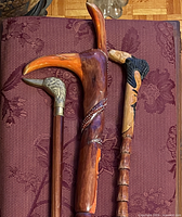 Top view of three carved canes showing handles and brass accents