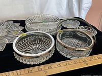 All eight pressed glass serving pieces grouped on black background with ruler for scale