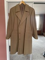 Front view of camel wool double-breasted overcoat on hanger