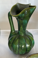 Front view of green glazed ceramic ribbed pitcher vase