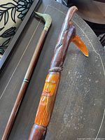 Both canes showing brass duck handle and carved face details