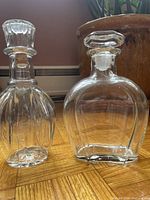 Front view of both glass decanters showing shapes and stoppers