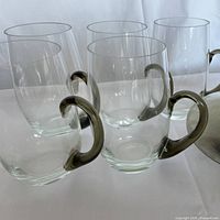 Five clear smoked-grey glass mugs grouped together