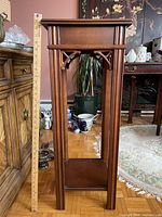 Full view of plant stand showing overall design, height against ruler, top and lower shelf