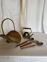 group view of coal scuttle, kettle and three utensils beside ruler for scale