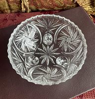 Top view of clear crystal bowl showing starburst and floral cut pattern, scalloped rim and interior detail