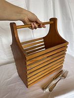 Overall view of wooden tote with utensils for scale