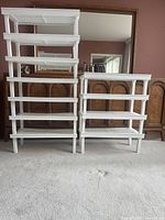 Two assembled columns of white plastic modular shelving showing overall structure and tier count