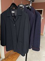 Three coats on hangers showing overall styles