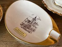 Top view of white porcelain ashtray with gold rim and Lambach building transfer print