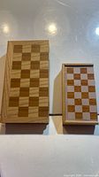 two closed folding wooden chess boards, large and small