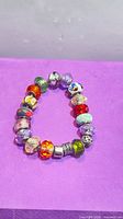 Full view of bracelet showing assortment of coloured glass charms