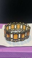 Front angled view of full bracelet showing amber glass stones and filigree metalwork