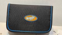 Front of closed black Boggle travel case with blue trim and logo