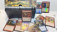 Open storage box showing large quantity of unsleeved MTG cards with several sample cards spread in front