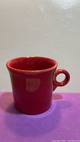 Side view of red Fiesta mug showing handle and glaze