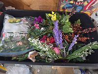 Top view of bin showing variety of faux flowers, lavender spikes, roses, greenery