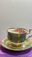 Paragon green and gold teacup on matching saucer, rose interior