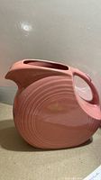 Side view of rose disc pitcher showing concentric ring design and handle