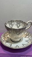 Front view of teacup on saucer showing silver leaf pattern