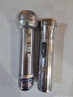 Two vintage chrome flashlights side by side