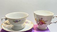Two teacups side by side, left with matching saucer