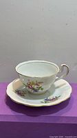 Teacup on saucer front view showing floral pattern and gold rim
