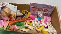 Box containing mixed Barbie accessories including footwear, combs, booklet