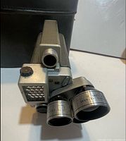 Front and side view showing turret and lenses with case behind
