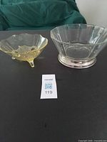 Amber footed bowl and clear bowl with metal base side by side