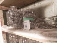 Stacks of small metal cage bowls next to larger bowls