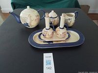 Full set showing teapot, sugar, creamer, cruets on tray and platter