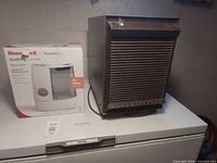 Kenmore dehumidifier beside boxed Honeywell warm-mist humidifier