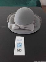 Top view of gray felt hat with bow and dotted net veil