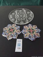 Pressed glass platter above two stacks of star-shaped decorative hot plates