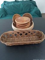 Group shot showing large salad bowl with six small bowls nested inside and wicker basket in front